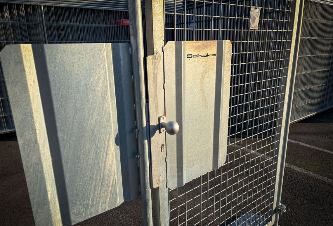 Bouwhek vluchtpoort detail van slot en schild dicht